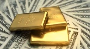 three gold bars on dollar bills
